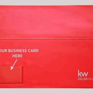 May include: Red plastic business card holder with a clear window for a business card. The holder has the text "YOUR BUSINESS CARD HERE" and an arrow pointing to the window. The bottom right corner has the logo "kw KELLERWILLIAMS."