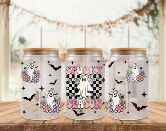May include: Three clear glass can wraps for 16 oz cans with wooden lids and straws. Each features a Halloween ghost design with bats, stars, and flowers. The center can wrap says "Spooky Season".