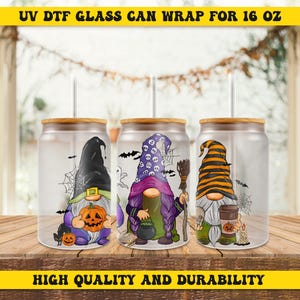 May include: Three glass can wraps for 16 oz cans with wooden lids, each featuring a Halloween gnome design. The gnomes wear witch hats and hold Halloween-themed items. The text "UV DTF GLASS CAN WRAP FOR 16 OZ" and "HIGH QUALITY AND DURABILITY" are visible.