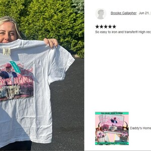 a woman holding up a t - shirt in front of a car