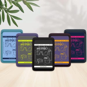 May include: A collection of five phone cases featuring a ski goggles patent design. Each case has a different color border, including blue, purple, and black. The text "SKI GOGGLES" is visible on each case.