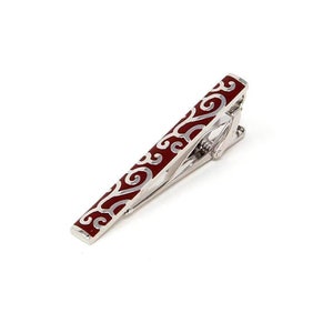 May include: A silver tie clip with a red enamel design featuring a swirling pattern.