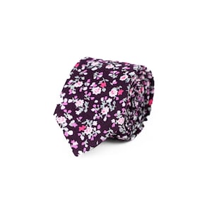 May include: A dark purple tie with a small pink and white floral pattern.