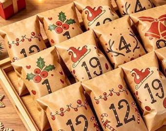 Op de afbeelding: Een verzameling bruine papieren zakjes in een houten dienblad, elk bedrukt met een zwart cijfer en feestelijke rood-groene kerstillustraties zoals hulst, zuurstokken en sleeën, naast twee kleine cadeauverpakkingen met rode linten.