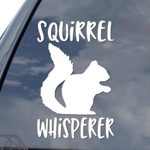 May include: White vinyl car sticker with the text "Squirrel Whisperer" and a silhouette of a squirrel.