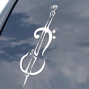 May include: White vinyl decal of a cello, applied to a car window. The cello design is a stylized, minimalist illustration, featuring the instrument's curves and details. The decal is a music-themed accessory.