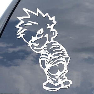May include: White vinyl decal of a cartoon boy urinating on a car window. The boy is wearing a striped shirt and has spiky hair. The decal is designed to be applied to a vehicle's rear window.