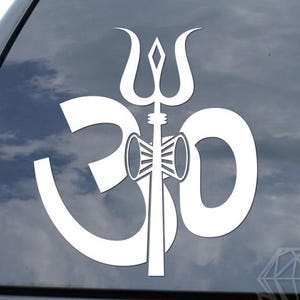 May include: White vinyl decal of the Om symbol with a trident design. The decal is applied to a car window. The Om symbol is a sacred sound and spiritual icon in Hinduism, Buddhism, and Jainism.