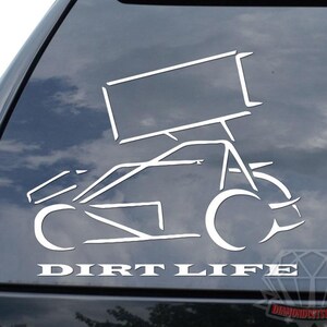 May include: White vinyl decal of a sprint car with the words "DIRT LIFE" in a bold font. The decal is applied to the rear window of a black vehicle. The design features a simplified outline of a race car.