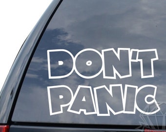 May include: White vinyl sticker with the text "DON'T PANIC" in a bold, cartoon-like font. The sticker is applied to the rear window of a black car.