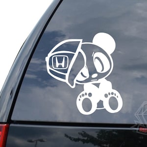May include: White vinyl sticker of a cartoon panda wearing a Honda emblem on its head. The panda is sitting with its legs crossed and has a cute expression on its face.