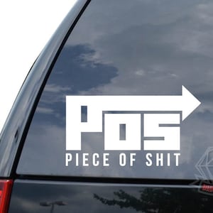 May include: White vinyl sticker with the acronym "POS" in large block letters and the words "Piece of Shit" underneath. The sticker is on the back window of a black car.
