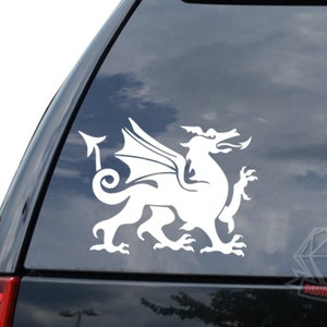 May include: White vinyl decal of a Welsh dragon with wings outstretched. The dragon is facing right and has a long, curled tail.