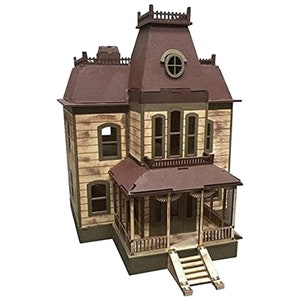 May include: A wooden model kit of a two-story house with a brown roof, white siding, and a porch. The house has a front door, windows, and a chimney. The model is assembled and ready to be displayed.