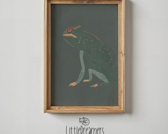 May include: A framed illustration of a green chameleon with orange and red accents on a dark green background. The frame is made of light brown wood.