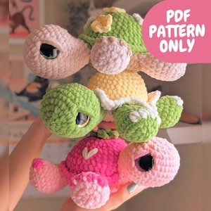 May include: A stack of handmade crochet turtle plushies in various colors. The turtles have large, expressive eyes and are in shades of pink, green, and yellow. The text "PDF PATTERN ONLY" is visible in the upper right corner.