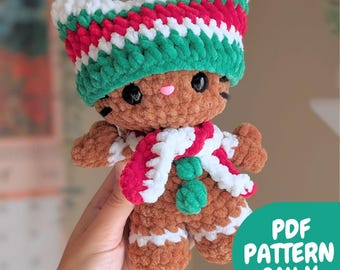 May include: A crocheted gingerbread cat doll with a festive hat and scarf. The doll is brown with white and red accents, black eyes, and a pink nose. The hat is green, red, and white. The scarf is red and white. Text on the image reads "PDF PATTERN ONLY."