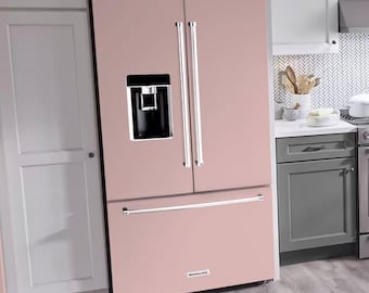 Puede incluir: Una cocina moderna con un refrigerador rosa, horno de acero inoxidable y gabinetes grises. La cocina cuenta con armarios superiores blancos, un protector contra salpicaduras estampado y un piso de madera. Una ventana proporciona luz natural.