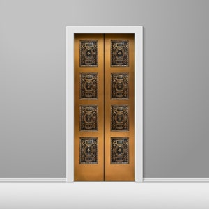 May include: A pair of ornate gold double doors with intricate black metal designs. The doors are set in a white frame against a gray wall.