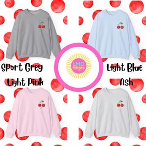 May include: Four sweatshirts with a cherry graphic on the front. The sweatshirts are in the colors sport grey, light pink, light blue, and ash.