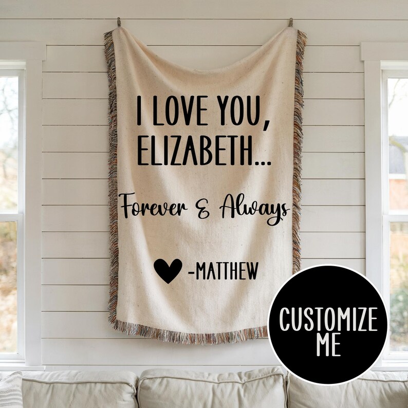 May include: A white throw blanket with black text that reads "I love you, Elizabeth... Forever & Always -Matthew". A black heart is above the name Matthew. The blanket has a fringe border.