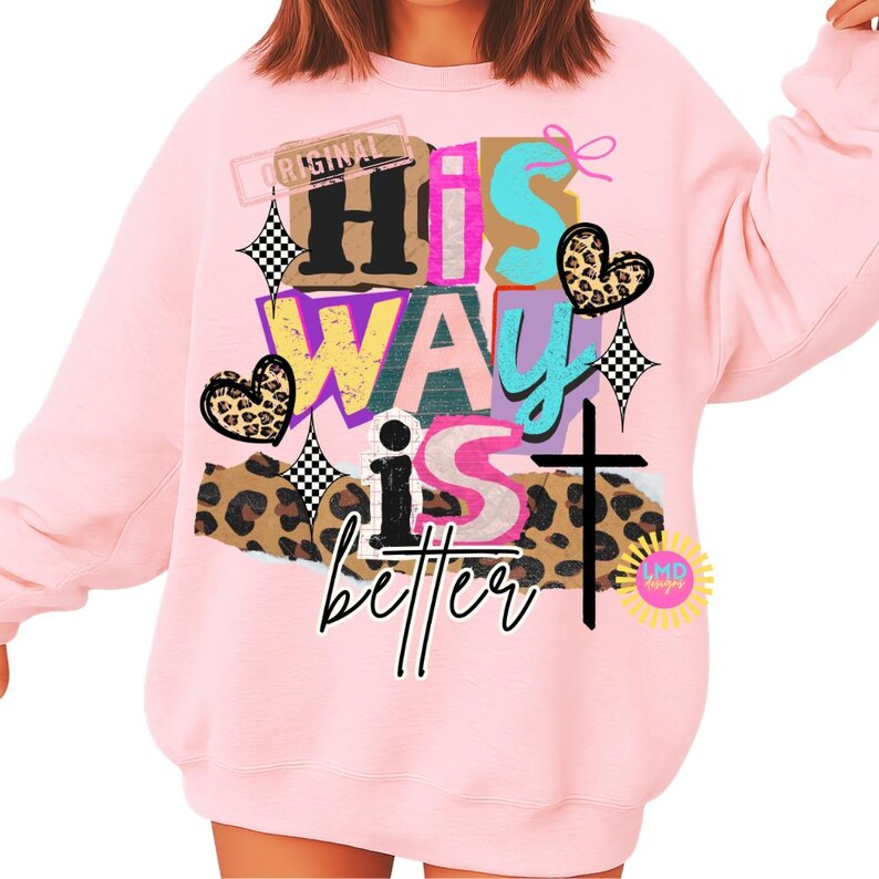 May include: A light pink sweatshirt with the text "His Way is better" in a collage style. The design includes a cross, hearts, and leopard print accents. The word "Original" is also visible.