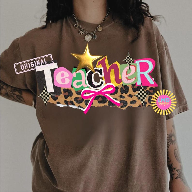 May include: A brown t-shirt with the word "Teacher" in a colorful, layered design. The design includes a gold star, a pink bow, and a leopard print section. The word "Original" is printed on a rectangular label.