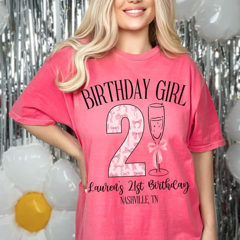 Może przedstawiać: R&oacute;żowy T-shirt z napisem "Birthday Girl" i r&oacute;żową cyfrą 21 z kieliszkiem szampana. Pod cyfrą znajduje się napis "Lauren's 21st Birthday Nashville, TN".