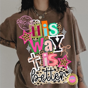 May include: Brown t-shirt with the text "His Way Is Better" in a colorful, patchwork design. The design includes stars, a cross, and leopard print accents. The shirt also has a "The Original" stamp.
