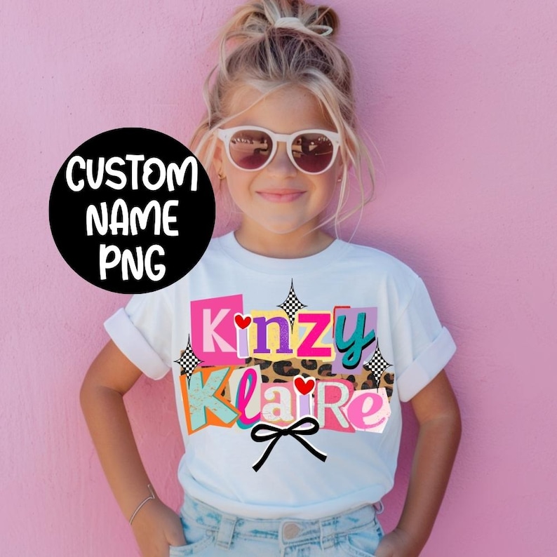 May include: A white t-shirt featuring the name "Kinzy Klaire" in colorful, block-letter style. The design includes a leopard print, hearts, and a black bow. The shirt is worn by a young girl wearing sunglasses, with the text "CUSTOM NAME PNG" in a black circle.