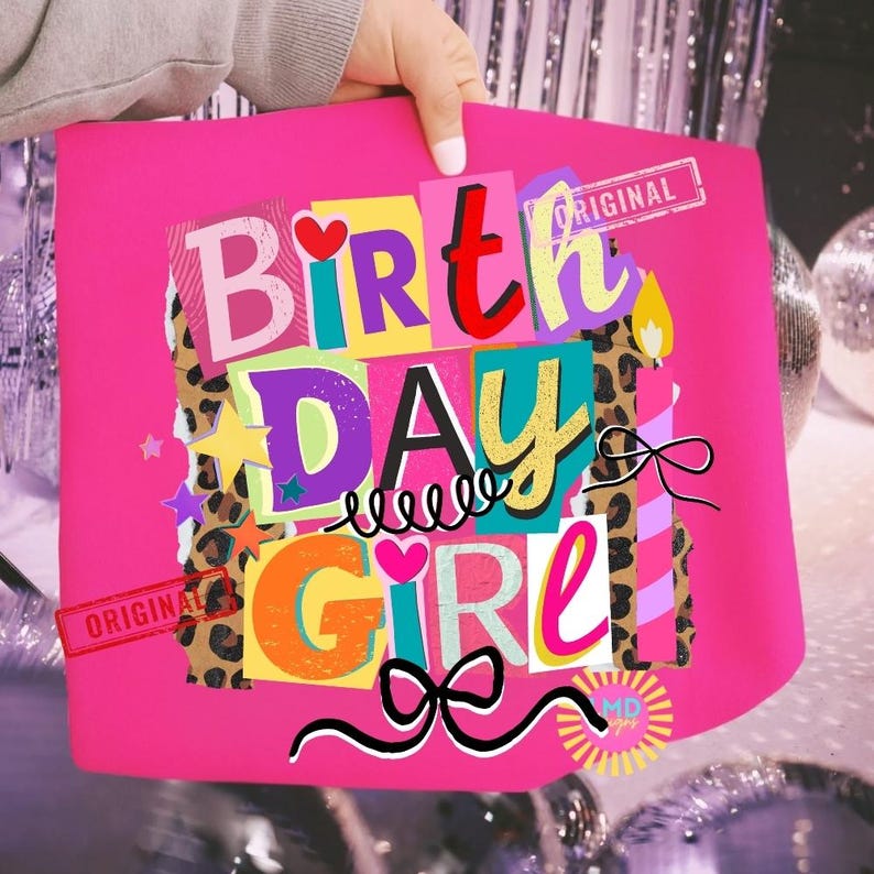 May include: A bright pink tote bag with the words "BIRTHDAY GIRL" in a colorful, collage-style design. The design includes hearts, stars, and a bow, with a leopard print accent. The word "ORIGINAL" is stamped on the bag.