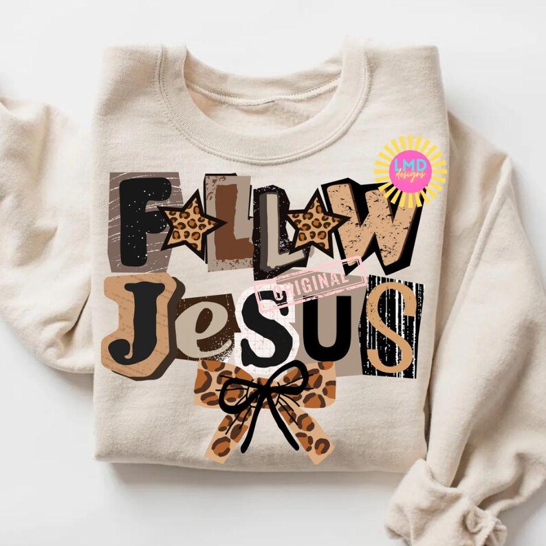 K&ouml;nnte beinhalten: Beiges Sweatshirt mit dem Schriftzug "FOLLOW JESUS" in einem Collage-Design. Die Buchstaben sind in verschiedenen Schriftarten und Farben gehalten, darunter Braun, Schwarz und Leopardenmuster. Eine Schleife mit Leopardenmuster befindet sich unten.