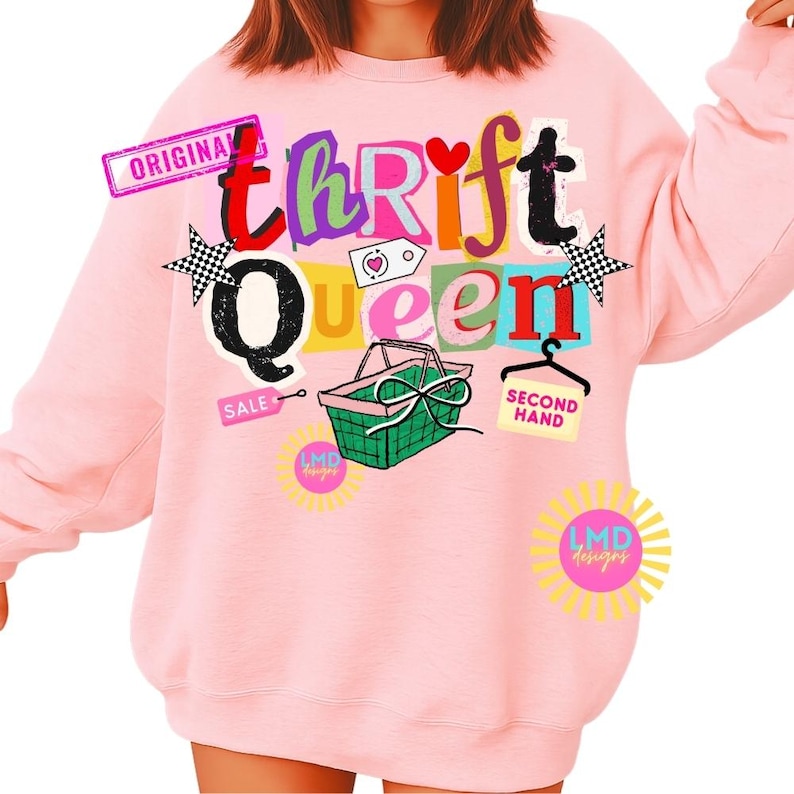 May include: A light pink sweatshirt with the words "Thrift Queen" in colorful, blocky letters. The design includes a green basket, stars, and the words "Original", "Sale", and "Second Hand".