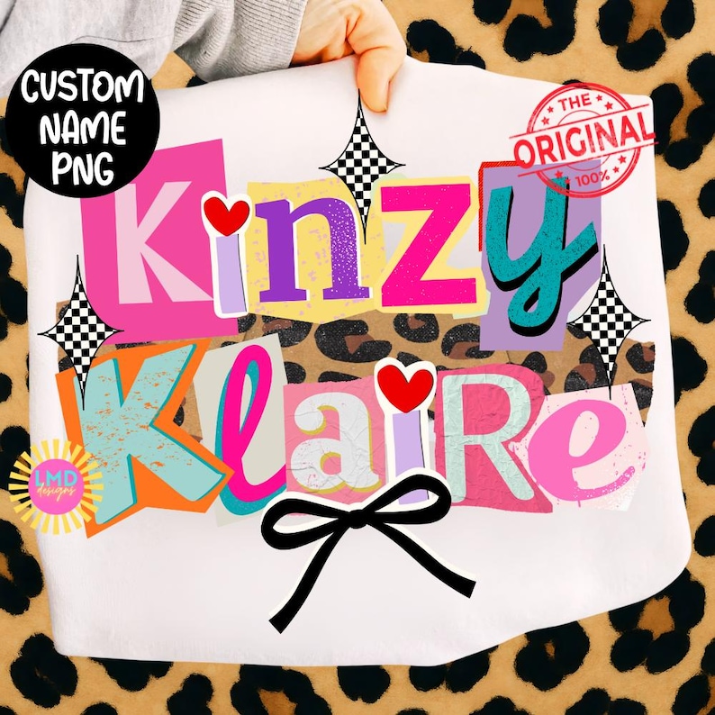 May include: White t-shirt with the names "Kinzy" and "Klaire" in a colorful, cut-out style. The design includes hearts, a black bow, and the text "CUSTOM NAME PNG" and "THE ORIGINAL 100%."