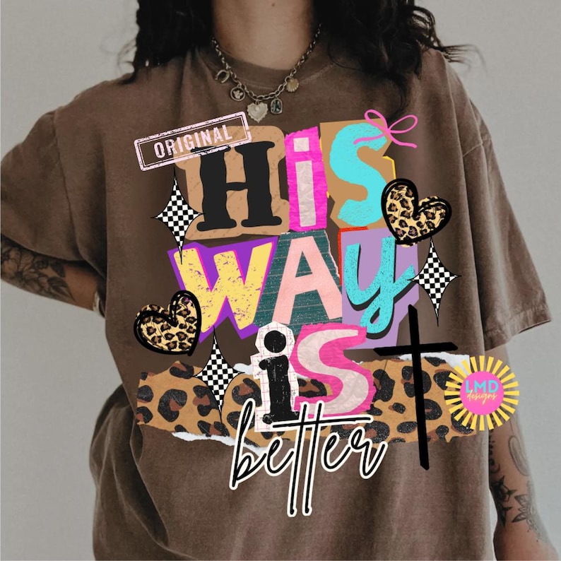 May include: Brown t-shirt with a colorful graphic that reads "His Way is better." The design includes a cross, hearts, and checkered starbursts. The word "Original" is printed on a rectangular label.