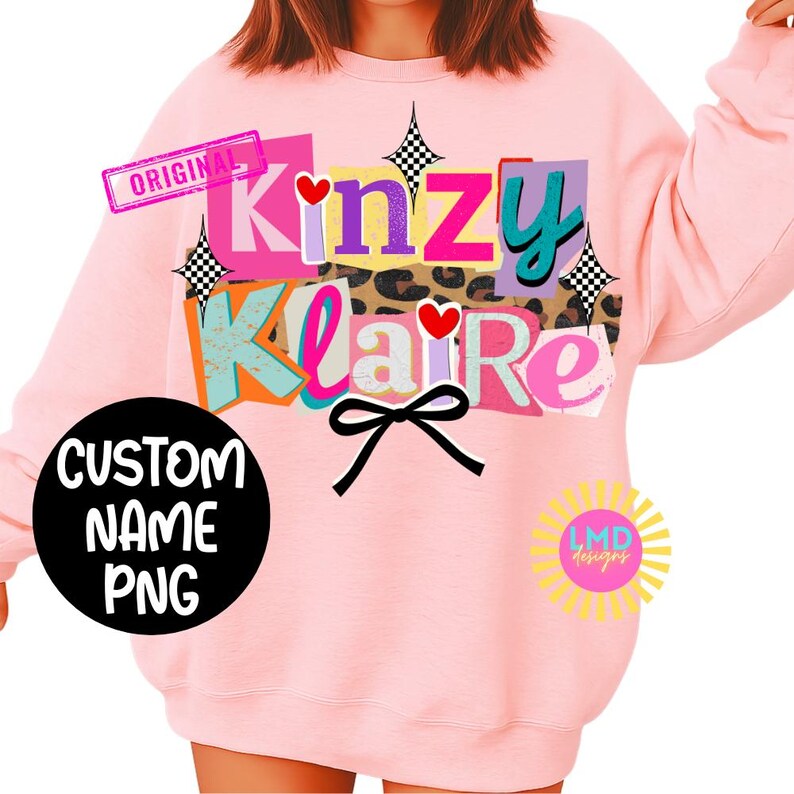 May include: Pink sweatshirt with the text "Kinzy Klaire" in a colorful, layered design. Features a black bow, hearts, and the words "Custom Name PNG" on a black circle. Includes a "Original" stamp.