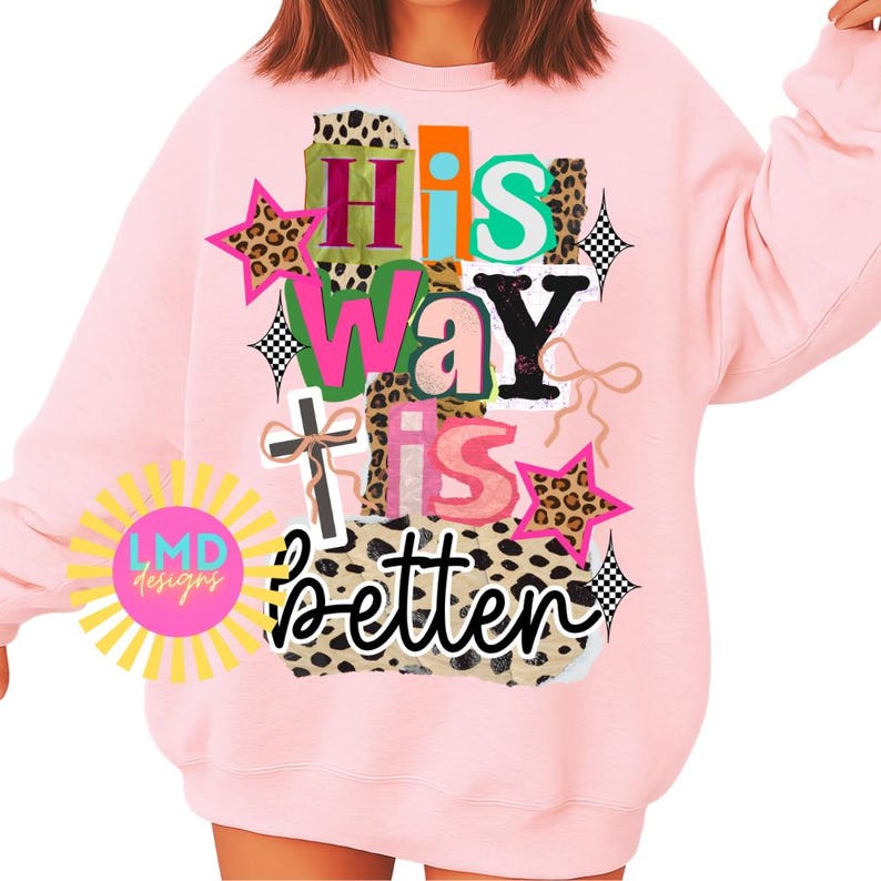 May include: A light pink sweatshirt with the text "His Way Is Better" in a colorful, layered design. The design includes leopard print stars, a cross, and the "LMD designs" logo.
