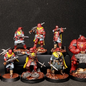 May include: A collection of eight miniature soldier figurines painted in red, yellow, and grey. The figures are equipped with various weapons including rifles, a polearm, and a heavy machine gun. Each miniature stands on a circular base.