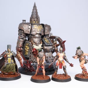 Puede incluir: Una colecci&oacute;n de figuras en miniatura, que incluye una figura grande y detallada con forma de robot y varias figuras de guerreros m&aacute;s peque&ntilde;as. Las figuras est&aacute;n pintadas con tonos met&aacute;licos y terrosos, y est&aacute;n colocadas sobre bases circulares marrones. El tema general sugiere un entorno de fantas&iacute;a o ciencia ficci&oacute;n.