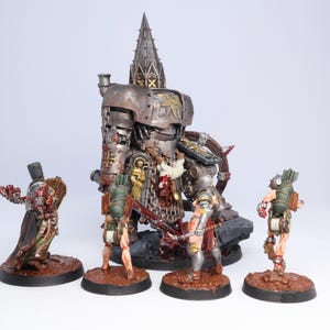 Puede incluir: Un conjunto de figuras en miniatura detalladas, que incluyen una gran m&aacute;quina de guerra met&aacute;lica de estilo g&oacute;tico y varias figuras m&aacute;s peque&ntilde;as en poses de batalla. Las figuras est&aacute;n pintadas con una variedad de colores y texturas, sobre bases marrones.
