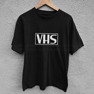 vhs shirt,
nostalgic shirt,
nostalgic tee,
90s shirt,
80s shirt,
movie fan gift,
movie fan shirt,
horror movie shirt,
vintage shirt,
cinephile hoodie,
y2k shirt,
retro movie shirt,
Retro Video Betamax