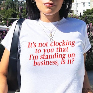 Y2K It&#39;s Not Clocking To You That I&#39;m Standing On Business Baby Tee Viral Quote Fitted Top Baddie Aesthetic Shirt Funny Meme Tee TikTok Meme