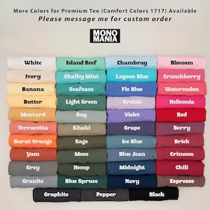May include: A display of folded t-shirts in various colors, including white, blue, green, and pink. Each shirt is labeled with its color name, such as "White," "Island Reef," and "Chambray." The brand logo "MONO MANIA" is visible.