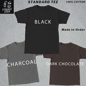K&ouml;nnte beinhalten: Drei kurz&auml;rmelige T-Shirts in den Farben Schwarz, Anthrazit und Dunkelschokolade. Der Text "STANDARD TEE", "100% COTTON", "Made to Order", "BLACK", "CHARCOAL" und "DARK CHOCOLATE" ist sichtbar. Ein Logo mit einer Blume und einem Pilz ist vorhanden.