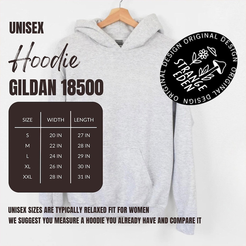 Puede incluir: Una sudadera con capucha gris jaspeado claro con bolsillo tipo canguro. El texto incluye UNISEX Hoodie GILDAN 18500, una tabla de tallas con medidas en pulgadas y un logotipo circular que dice STRANGE EDEN ORIGINAL DESIGN con un gr&aacute;fico de flor y seta.
