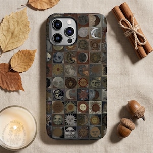 May include: A rectangular smartphone case featuring a grid pattern of various celestial illustrations including suns, moons, and stars in muted earth tones of brown, beige, and grey. The case has a cutout for a triple-lens camera system on the back.