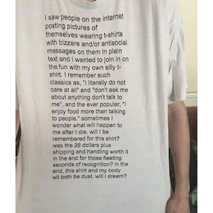 May include: White t-shirt with black text. The text is a lengthy, introspective message about the shirt's purpose and the fleeting nature of life. The shirt's message is written in a casual, conversational tone.