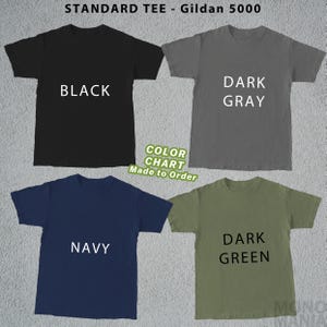Peut inclure: Un nuancier pr&eacute;sentant quatre t-shirts Gildan 5000 standards en noir, gris fonc&eacute;, marine et vert fonc&eacute;. Chaque chemise affiche son nom de couleur en texte blanc. Le nuancier comprend &eacute;galement le texte "Color Chart Made to Order."