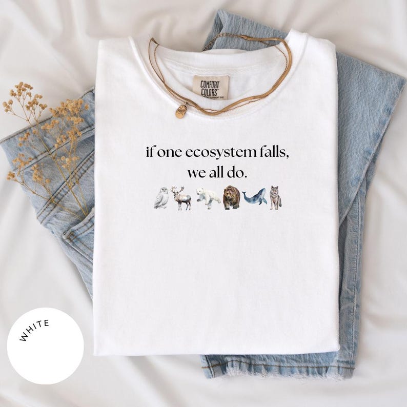 May include: White t-shirt with the text "if one ecosystem falls, we all do." and a row of watercolor animal illustrations including an owl, moose, polar bear, bear, whale, and wolf.