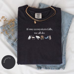 May include: Black t-shirt with the text "if one ecosystem falls, we all do." and a row of animal illustrations below the text.